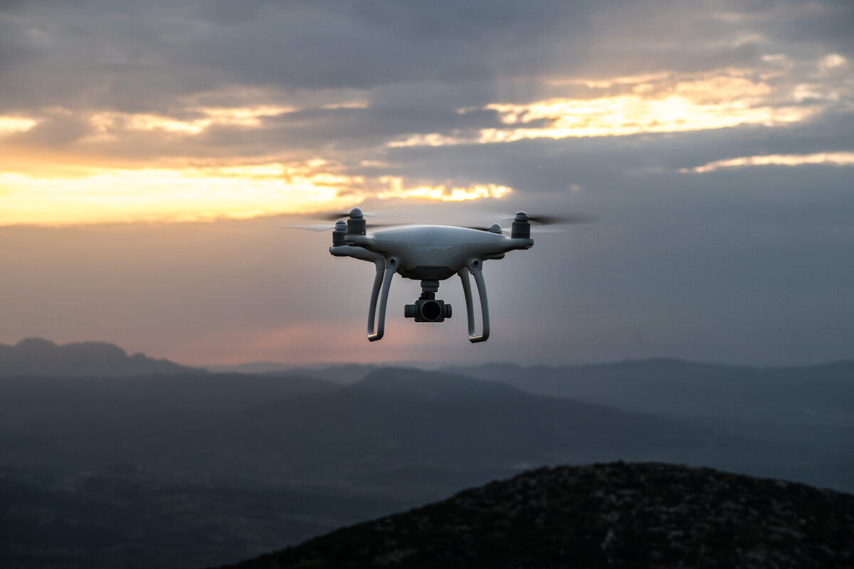 Survey drone in flight over wooded hills