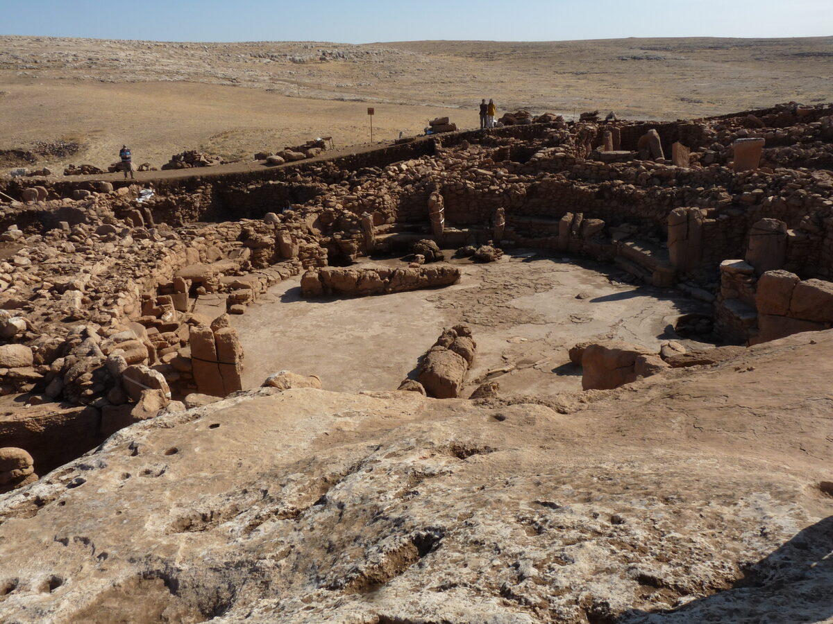 Vue d'ensemble du site de Karahan Tepe en Anatolie du sud-est, avec ses structures de pierre dégagées sur une colline rocheuse aride.